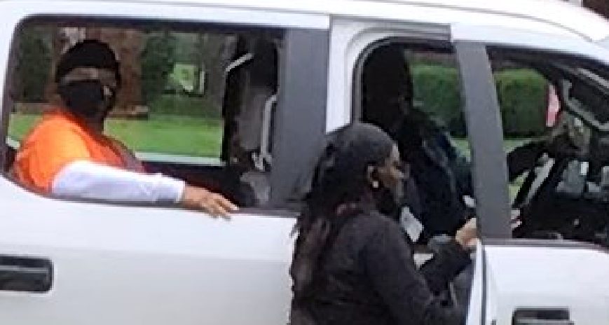 Detroit employees get in truck after steeling Scotty Boman signs. Photograph by theft victim Wendy Clark.